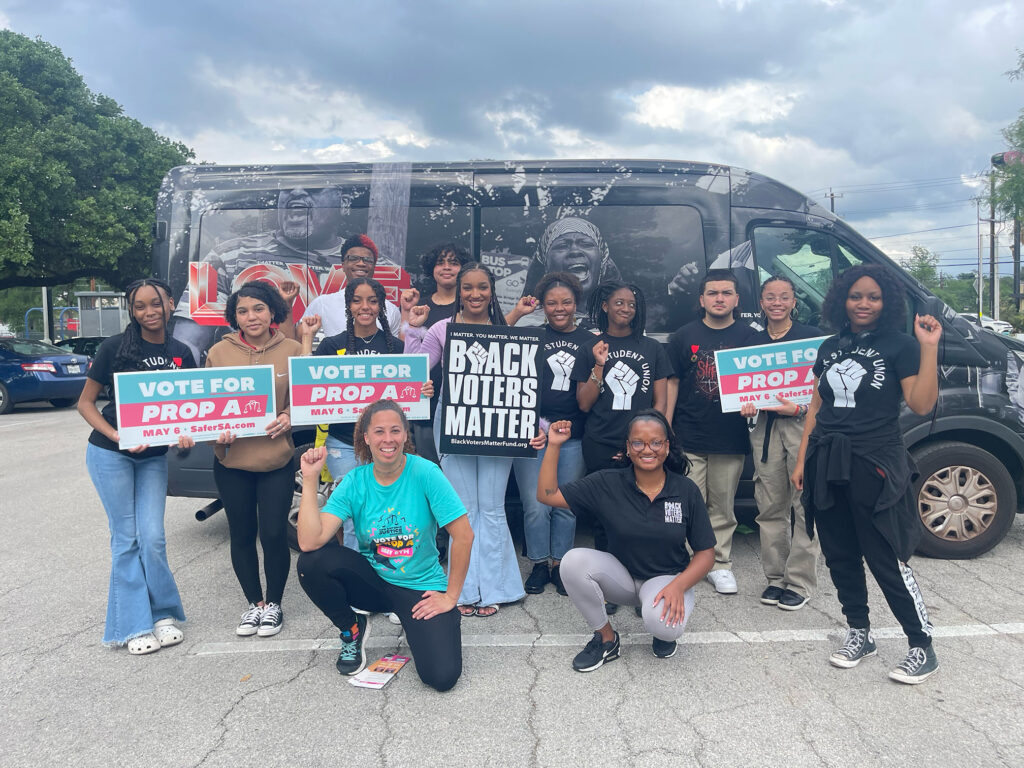 People holding signs in front of a van black votes matter